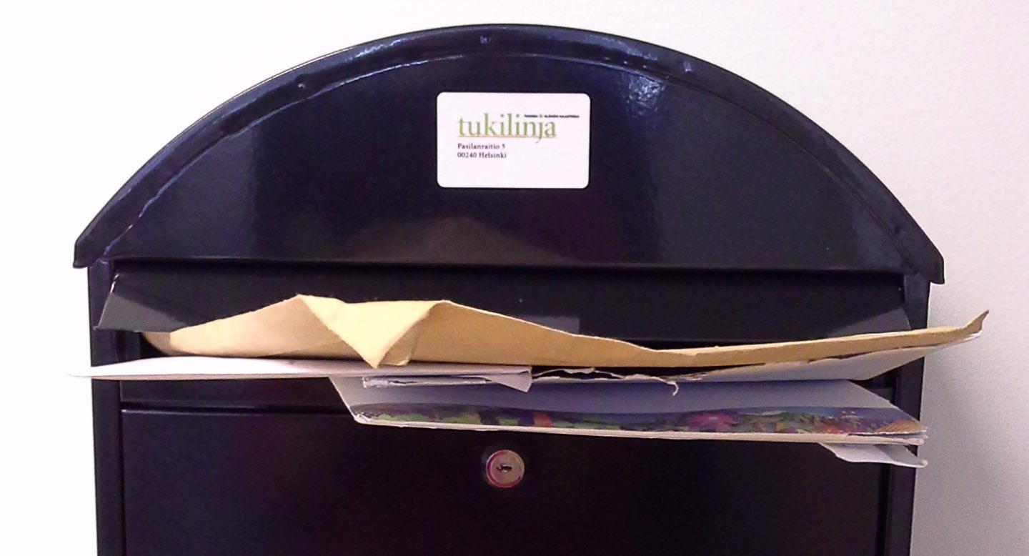 Tukilinjan postilaatikko, jossa tulvii kirjeitä.