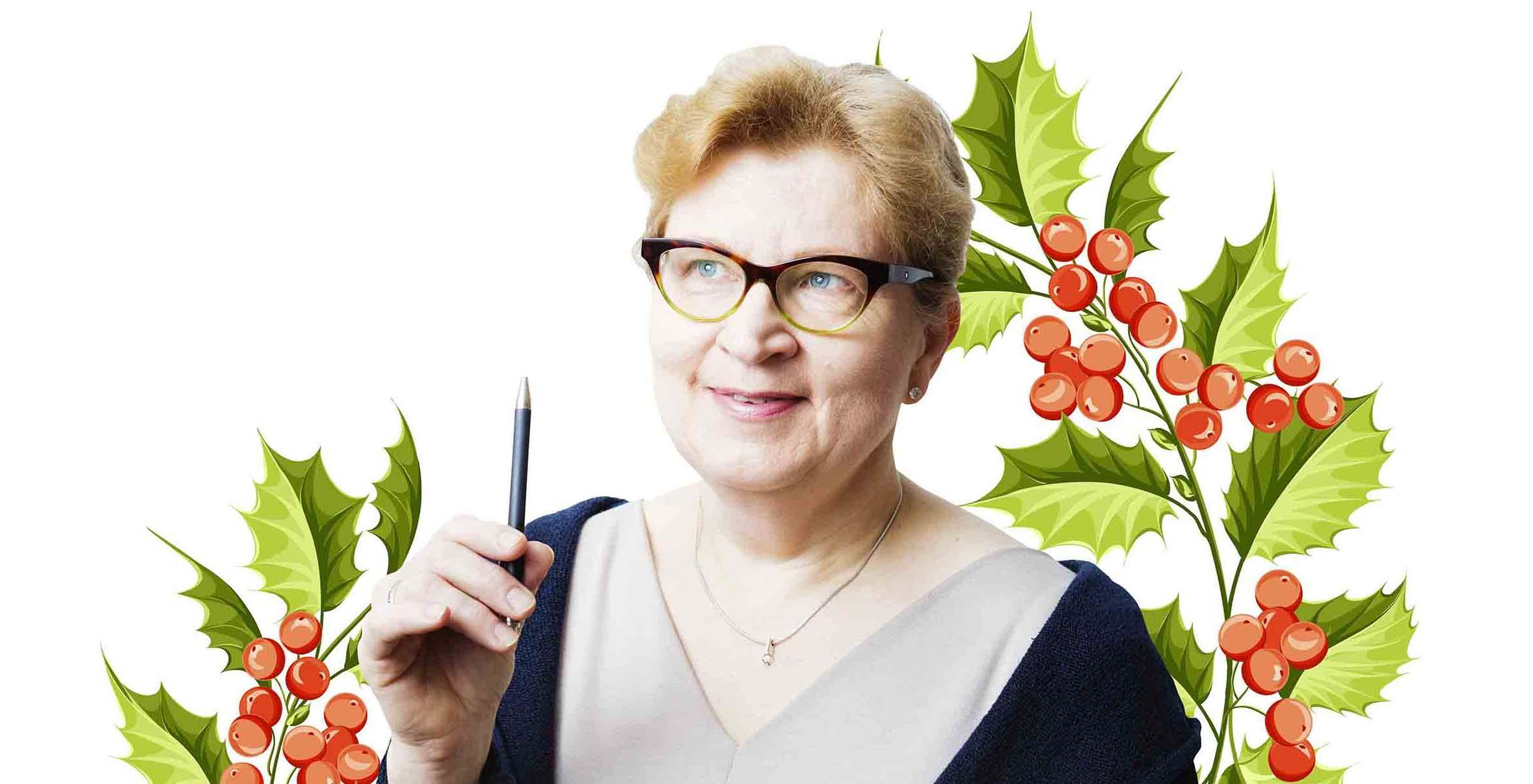 Iloinen, silmälasipäinen nainen pitää kynää kädessään. Taustalla piirrettyjä joulumisteleitä.